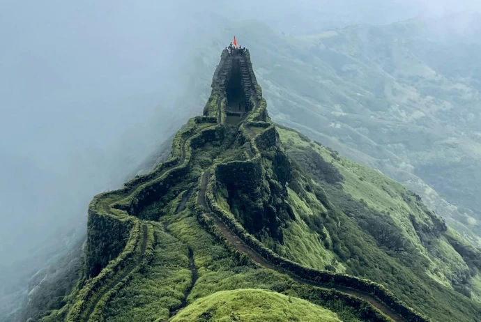 a very tall green mountain with a very steep hill